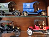 trois voitures anciennes exposées dans une vitrine
