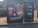 two vending machines sitting on the side of the road