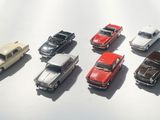 several toy cars are lined up in a row on a white surface