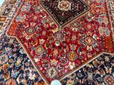 a cat that is sitting on a rug on the floor