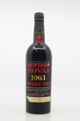 a bottle of red wine sitting on top of a white table