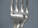 a close up of a silver fork with a hole in it