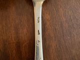 a silver spoon with a handle on a wooden table