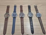 Quatre montres différentes sont alignées sur une table en bois