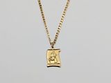 a gold plated necklace with a small lion on it