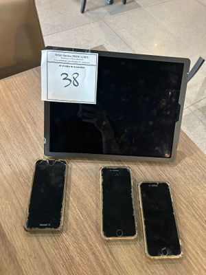 three cell phones sitting on a table next to a laptop