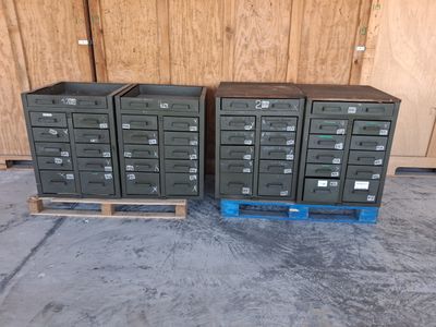 deux piles d'armoires de classement métalliques posées sur des palettes dans un garage