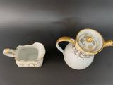 an image of a white and gold tea pot and a small cup