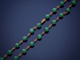 a gold and jade bead necklace, by person