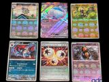 quatre cartes Pokémon différentes posées les unes sur les autres sur une table