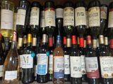 many bottles of wine sitting on a shelf next to each other