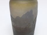 a brown and black vase sitting on a white surface