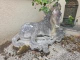 une statue représentant un cheval assis par terre