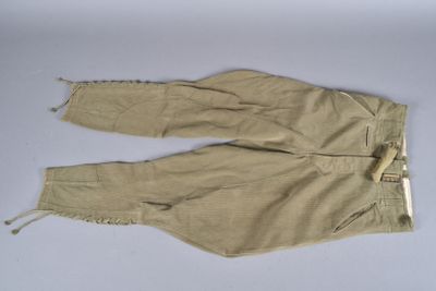 un pantalon beige avec des fermetures éclair sur un fond blanc