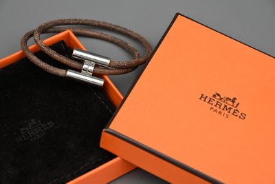une boîte orange posée sur une table, contenant un bracelet