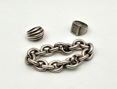 a silver chain and a ring on a white surface
