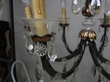 a chandelier that has a candle and a candle holder on it