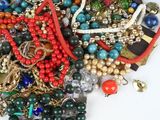 a pile of assorted jewelry on a white surface