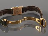 a close up of a wrist with a gold plated watch on it