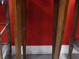 three wooden stools and a table in a room with a red wall