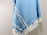 a blue skirt hanging on a wall with a white lace trim