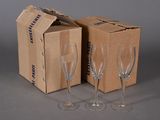 two empty wine glasses sitting next to a box of empty wine glasses