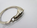 an image of a silver ring with a clasp on a white surface