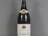 une vieille bouteille de vin posée sur une table en verre