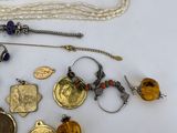 a lot of jewelry on a white plate on a table