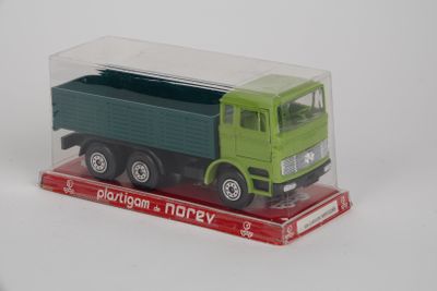 un petit camion jouet vert et vert dans une boîte transparente