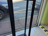 a person sitting at a table with a cell phone in front of a window