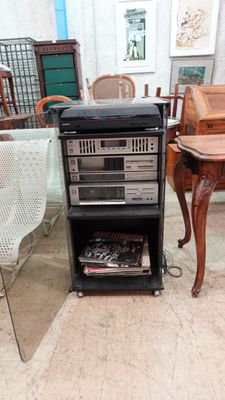 une table avec une radio posée dessus et une chaise devant