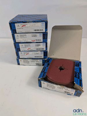 trois cartons remplis de livres sont empilés les uns sur les autres sur une surface blanche