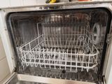 a dishwasher in the middle of a kitchen with a lot of dishes inside of it