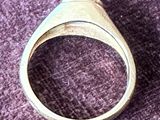 une bague en argent posée sur une surface violette