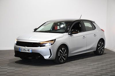 une voiture blanche est garée dans une pièce au sol à carreaux