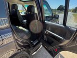 a black suv with its door open on the side of the road