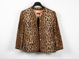 a leopard print jacket hangs on a hanger against a white wall