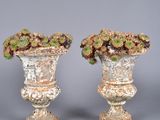 pair of vases with flowers on top of them on a gray surface