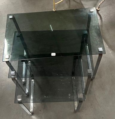 une table en verre avec un piètement en métal et une étagère en verre