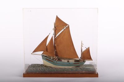 une petite maquette de voilier dans une vitrine