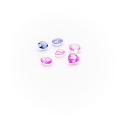 a group of pink, blue and white gems on a white surface