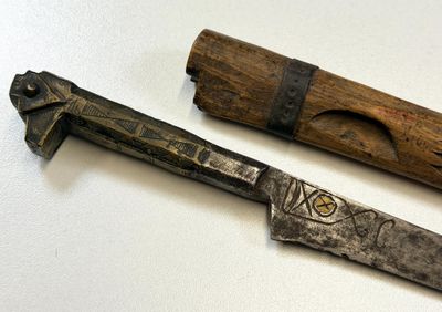two different types of knives on a white surface