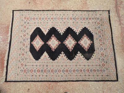 un tapis posé à même le sol, orné d'un motif noir et blanc