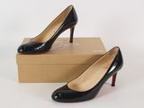 a pair of black high heels sitting on top of a box