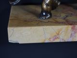 a bronze statue of a cat on a marble block