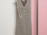 a dress hanging on a rack in front of a pink wall