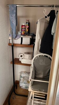 un petit placard avec une chaise et un portant à vêtements