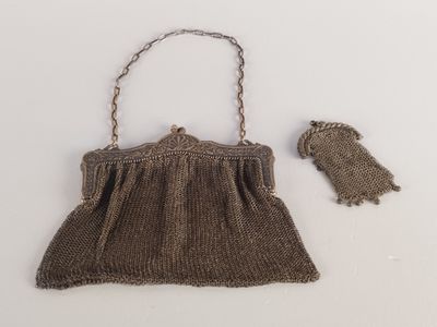 un vieux sac à main marron auquel est accrochée une chaîne sur le côté