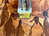 tableau représentant un groupe de manchots sur une table en bois sur laquelle est posé un morceau de papier